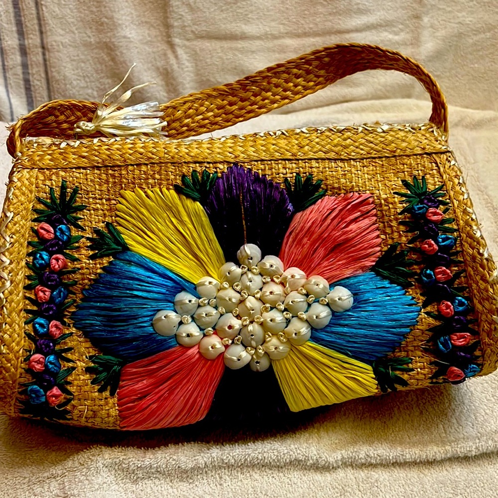 Hand crafted straw bag decorated with multi colored straw flower w/ shells.